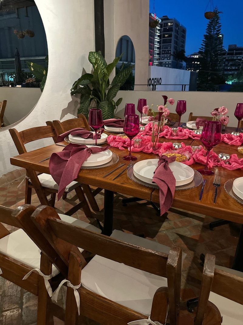 Mesa de evento social en terraza con mantelería vino y vista a la ciudad